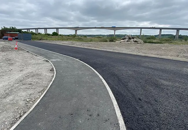 Newly surfaced road with a bridge in the background
