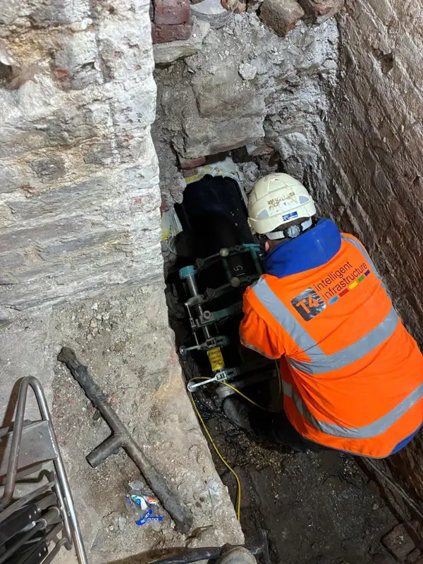 T4 operative working in a narrow excavation at the Royal Opera Arcade, London